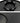 Black wheel hub cap assembly with circular opening and four metal retaining clips