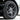 Silver wheel center hub cap on black alloy rim with tire