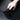 Hand pressing a black TPE underseat protector cover into place on a floor mat