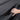 Hand adjusting a black car door storage organizer tray in the door panel