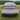 Rear view of full-width LED taillight bar on white Tesla with red running light