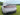 Full-width LED taillight bar on white car rear with red accent lighting