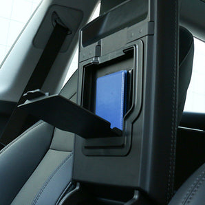 Car armrest storage box in rear seat, lid open showing blue insert