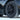 Multi-spoke black wheel cover with center cap; tire tread visible