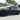 Black multi-spoke wheel cover on a rear wheel of a car