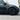 Black multi-spoke wheel cover on the front wheel of a car