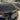 Dark black rear trunk spoiler with green trim line, angled view