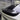 Black carbon fiber rear wing spoiler overlay installed on vehicle hatch with lip profile
