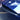 Carbon fiber front bumper inlay on blue bumper, close-up of glossy weave edge