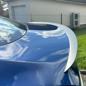 Carbon fiber rear spoiler installed, highlighting curved outline and woven finish