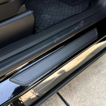 Carbon fiber door sill cover strip with silver edge and dark blue weave