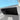 Installed dark carbon fiber glove box cover panel with textured finish in car interior