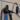 Wall-mounted EV charging cable holder with black clip and coiled cable, blue cloth