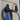 Wall-mounted EV charging cable holder with black plug inserted and cables looped