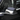 Glossy carbon fiber side mirror cover with dark weave texture on car