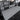 Gray camping bed extension board extended in rear cargo space with black sides