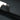 Dark gray woven strap stitched to carpeted trunk liner, close-up view