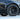 Black multi-spoke wheel cover with center cap; tire and spokes in focus