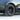 Dark multi-spoke wheel cover with center cap and tire on car wheel