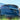 Black carbon fiber rear spoiler on a dark blue Tesla, angled rear close-up.