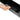 Hand closing a black under-seat storage box lid with molded interior visible.