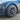 Dark gray wheel hubcap with multi-spoke aero design and circular center cap on car