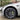 Matte black aero hubcap installed on front wheel, turbine-style spokes