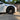 Black wheel cover on a front wheel of a white car, shown from the side