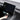 Hand pulling under-screen organizer from dashboard console, black tray open