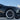 Close-up of black multi-spoke 18-inch wheel cover with tire on dark vehicle