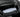 Folded white self-inflating air mattress inside a black vehicle cargo area