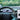 Car dashboard display showing a vehicle view with steering wheel controls