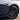Wheel with dark multi-spoke rim, circular center cap emblem, and brake caliper visible