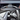 Turn signal lever stalk with light and wiper icons on Tesla steering column, dark gray.