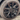 Wheel cover with dark multi-spoke pattern and center cap, shown on the front wheel with tire