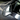 Close-up carbon fiber mirror cover showing dark weave pattern and curved chrome border