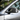 Carbon fiber side mirror cover on silver car door, dark weave texture and reflective edge