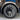 Gun gray wheel cover with turbine-style spokes and center hub on mounted tire