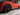 Black wheel cover with multi-spoke design on wheel of red car
